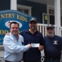 GK Kevin Strommer and Chairman Billy Preston present President of the Country Kids food pantry with a check for $2500.